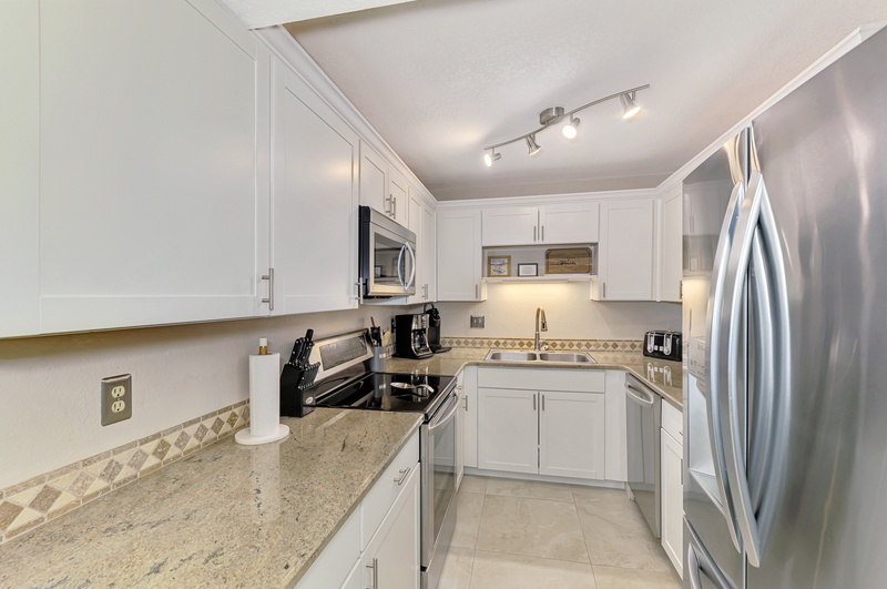 Your fully equipped kitchen features granite countertops, stainless steel appliances, and crisp white cabinetry for all your culinary adventures.