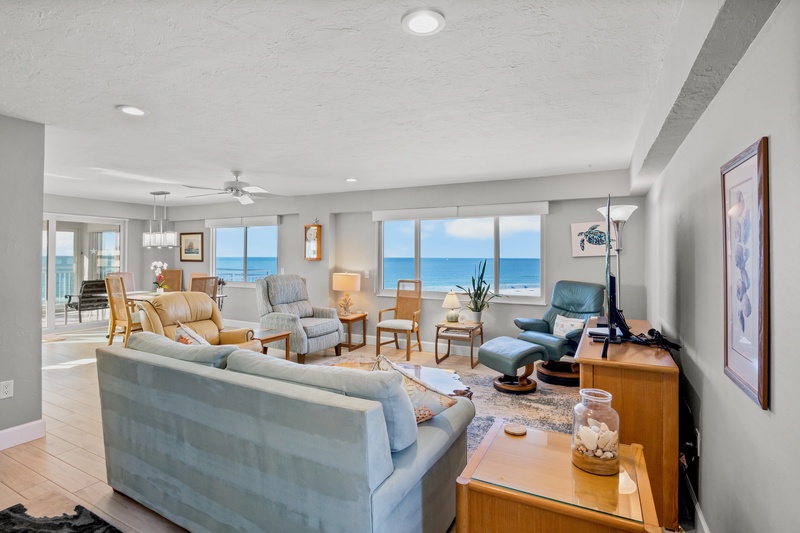 Unwind in your spacious oceanfront living room where floor-to-ceiling windows frame endless blue views and comfortable seating invites you to relax.