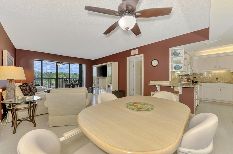 Spacious open-plan living with dining table for four and kitchen, plus balcony access for outdoor relaxation.
