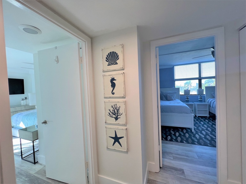 Your coastal-themed hallway connects beautifully appointed bedrooms, where charming nautical artwork guides you through your beach house retreat.