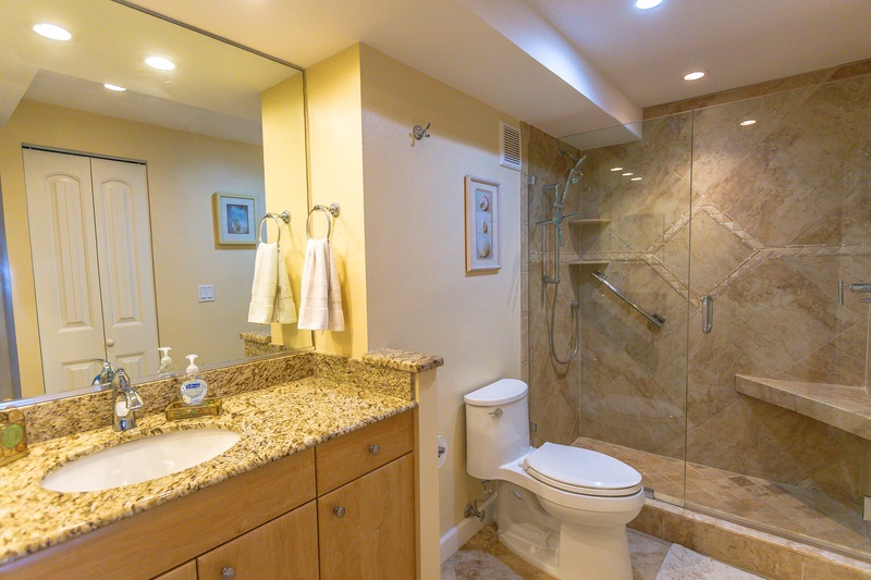 Luxurious bathroom with granite counters, glass shower, and plush towels for your ultimate relaxation.