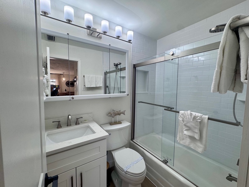 Refresh in your sparkling clean bathroom with modern fixtures, vanity lighting, and glass shower doors—plus fluffy towels ready for you.