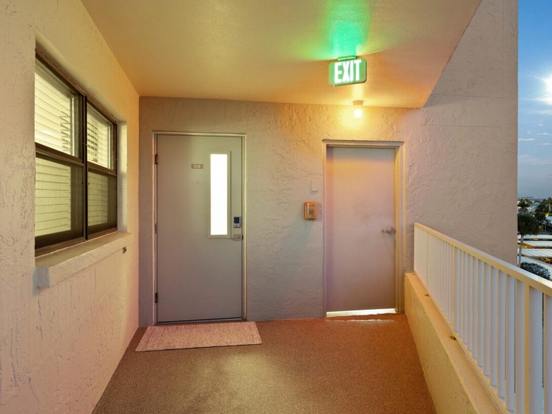 Your private entrance awaits with a welcoming covered hallway featuring warm lighting and easy stair-free access to your door.
