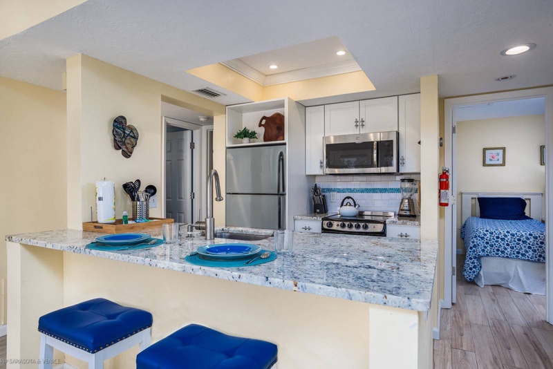 Your fully equipped kitchen features granite counters, stainless appliances, and cheerful blue accents for comfortable meal prep.