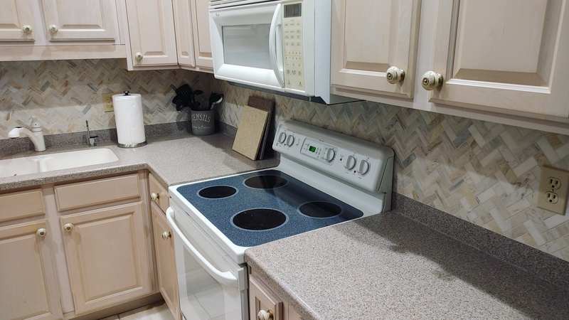 Your fully equipped kitchen awaits with modern appliances and elegant herringbone backsplash for memorable meal prep.