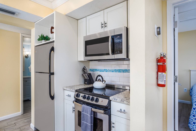 Your compact kitchen has everything you need - full-size appliances, granite counters, and charming blue tile accents for easy meal prep.