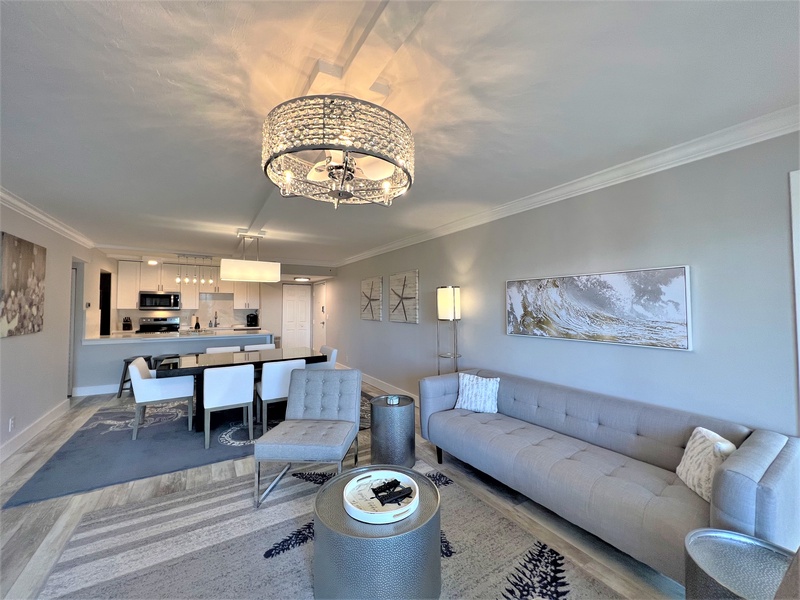 Relax in your elegantly appointed living space, where sparkling chandeliers cast warm light over plush seating and modern furnishings create the perfect retreat.