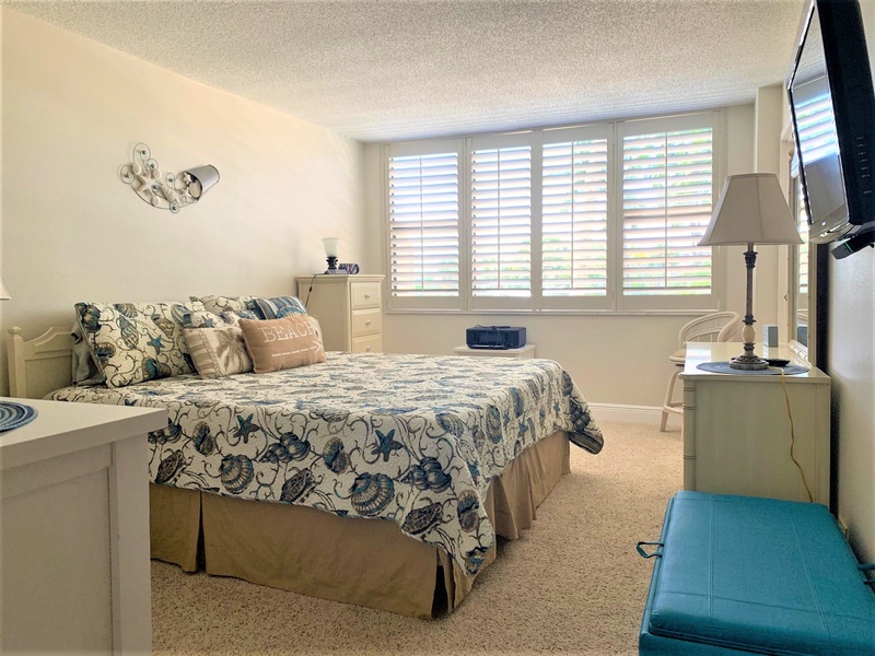 Sink into your peaceful bedroom sanctuary with coastal charm and ocean views through plantation shutters.