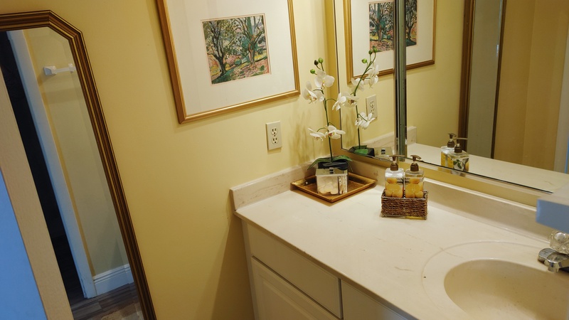 Your private bathroom features elegant touches with fresh orchids, quality amenities, and thoughtful artwork creating a spa-like retreat for your daily routine.