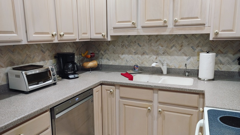 Your fully equipped kitchen features granite counters, modern appliances, and elegant herringbone backsplash for memorable meal preparation.