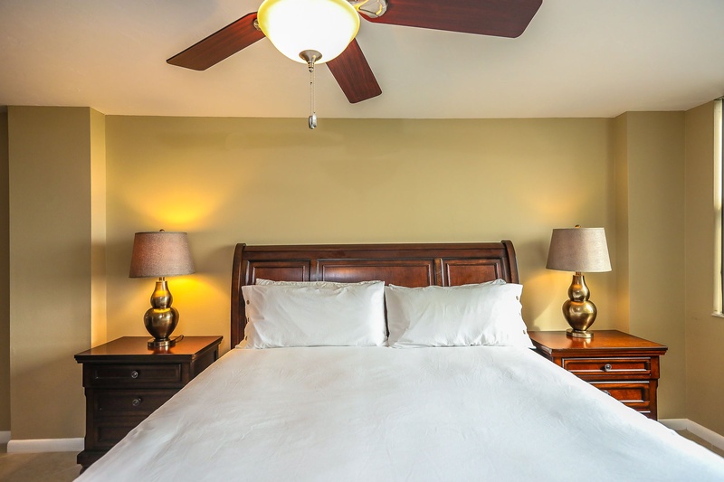 Sink into crisp white linens in your elegant bedroom, where warm lighting and classic furnishings create the perfect retreat after exploring.