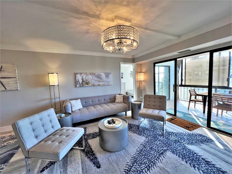 Relax in your stylish living room with sophisticated furnishings, crystal chandelier, and private balcony access overlooking the city.