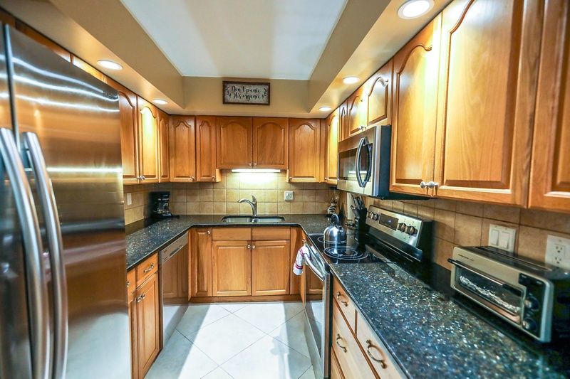 Your fully equipped kitchen features granite counters, stainless appliances, and warm wood cabinets—perfect for creating memorable meals during your stay.