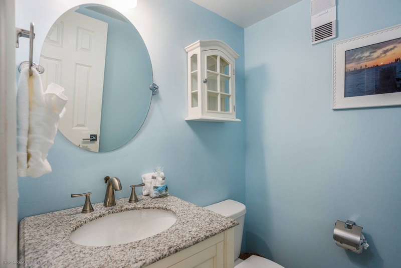 Step into your serene powder room where soft blue walls and granite countertops create a peaceful coastal vibe for refreshing moments.