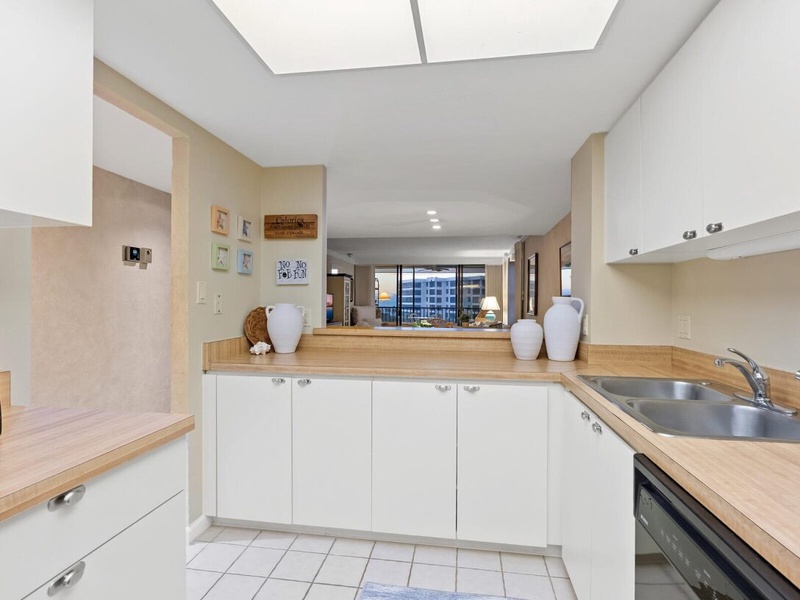 Your fully equipped kitchen opens beautifully to the living space, with warm wood counters and city views beyond.
