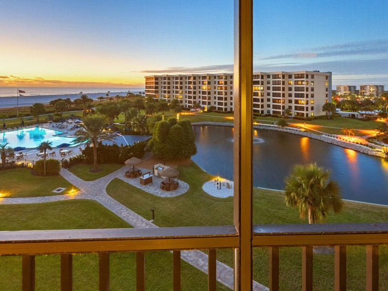 Stunning sunset views showcase the resort's pool, lagoon, and oceanfront setting from your private balcony.