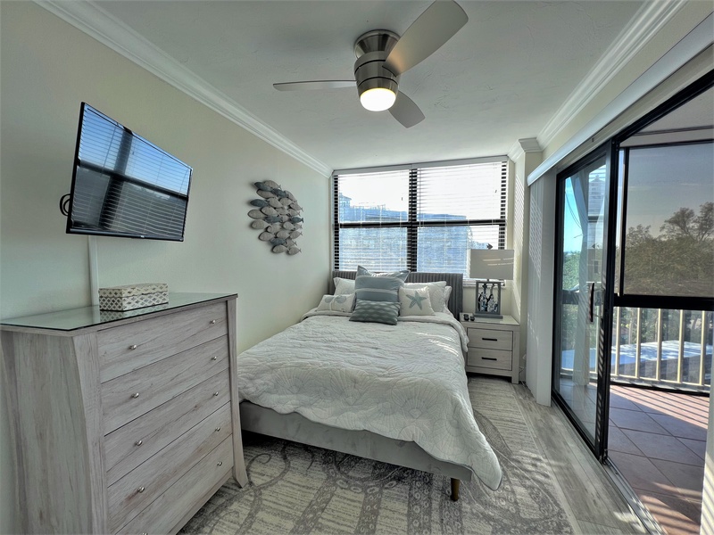 Your tranquil bedroom features elegant furnishings and a wall-mounted TV, with sliding doors opening to your private balcony.