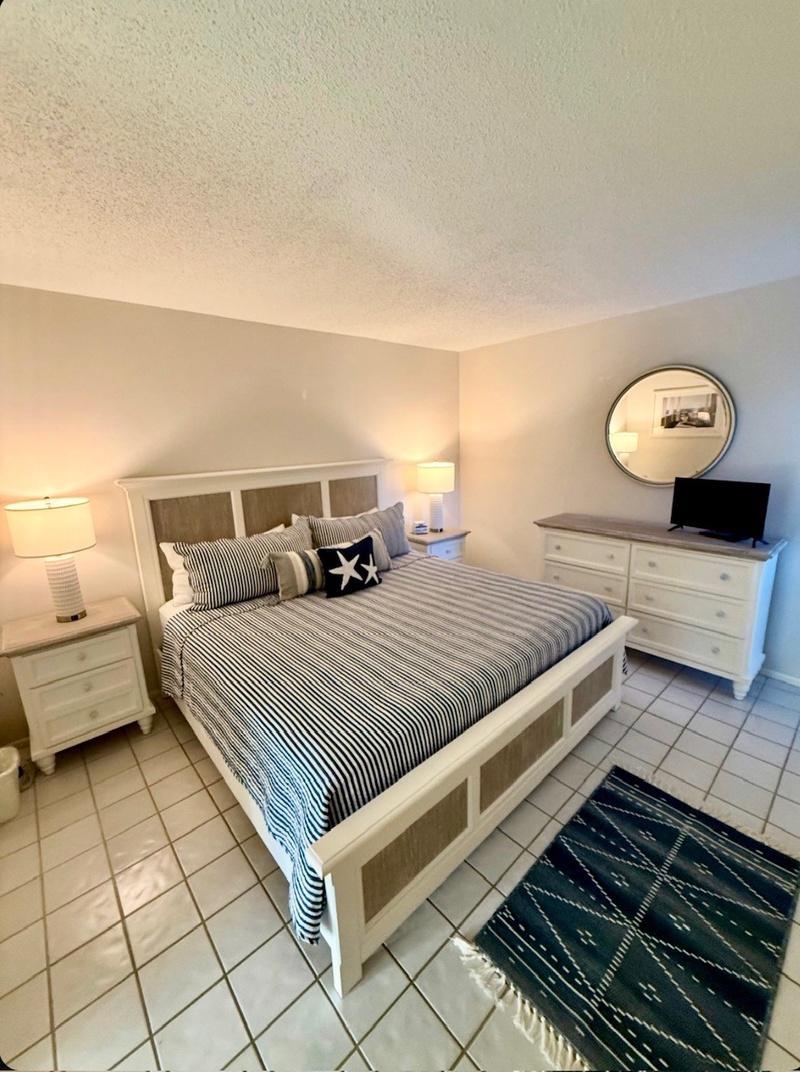 Rest peacefully in your comfortable bedroom with crisp nautical bedding, warm lighting, and thoughtful furnishings creating the perfect coastal retreat atmosphere.