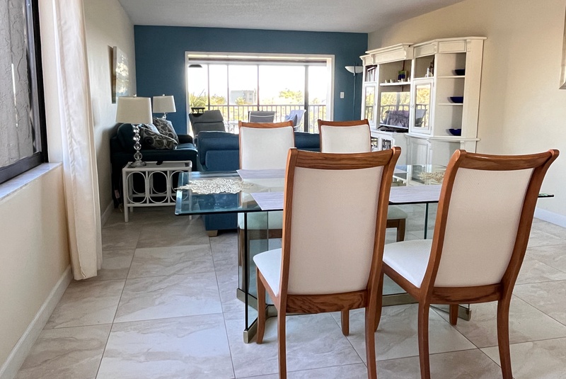 Your spacious living area flows seamlessly into the dining space, where you'll enjoy meals around the glass table while natural light pours in.