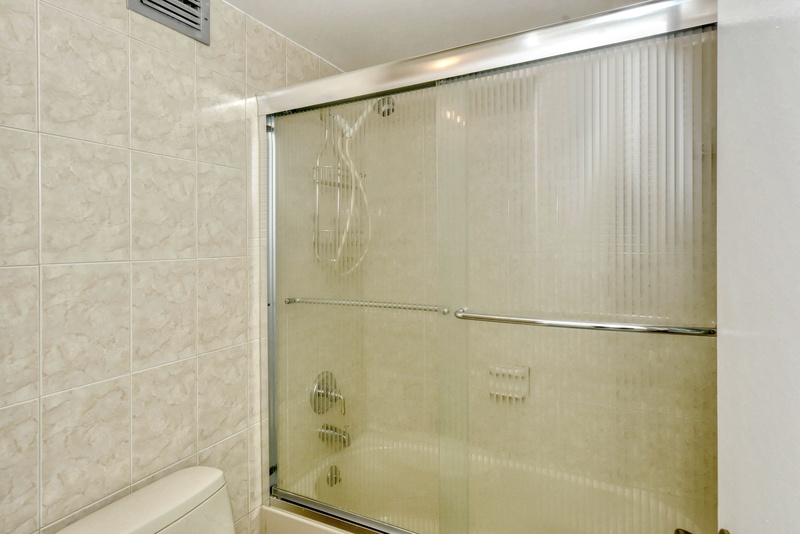 Step into your private marble sanctuary with a pristine glass-enclosed shower featuring elegant chrome fixtures and refreshing rainfall experience.