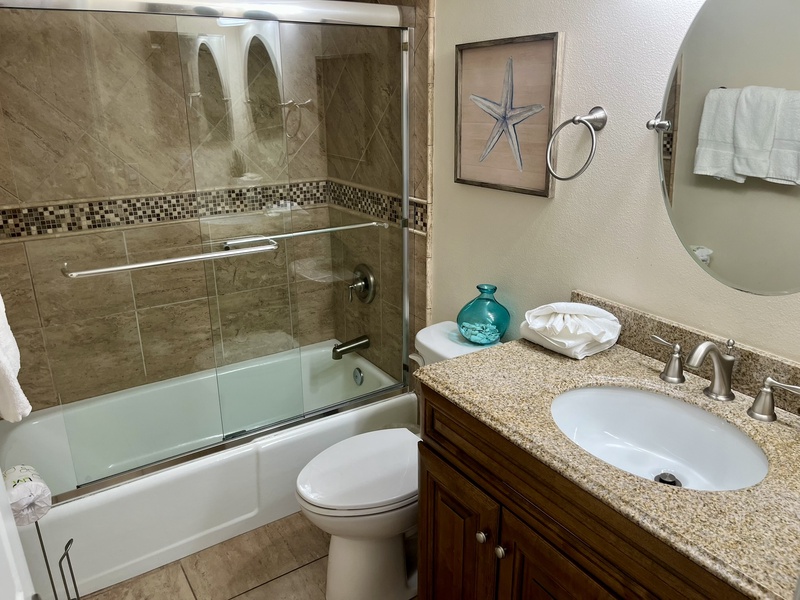 Refresh in your beautifully appointed bathroom with granite countertops, elegant glass shower, and coastal touches that create a spa-like retreat.