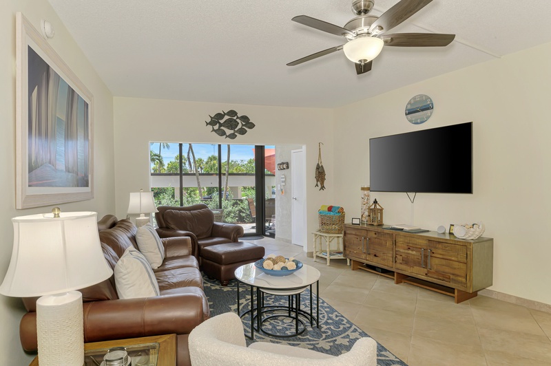 Unwind in your bright, airy living room with plush leather seating and tropical garden views through your sliding glass doors.