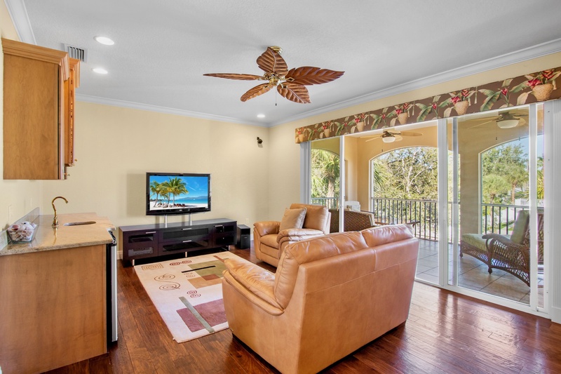 Second living room with plush seating, balcony, and TV