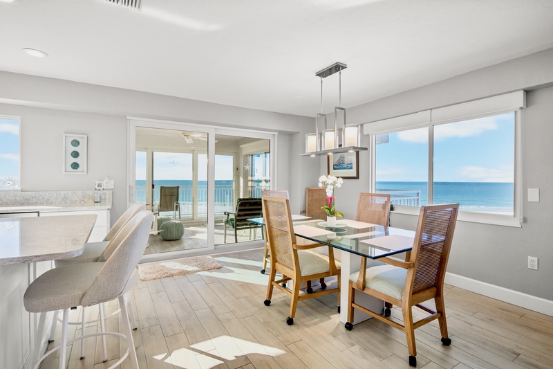 Your oceanfront dining room offers stunning sea views while you enjoy meals at the elegant glass table.