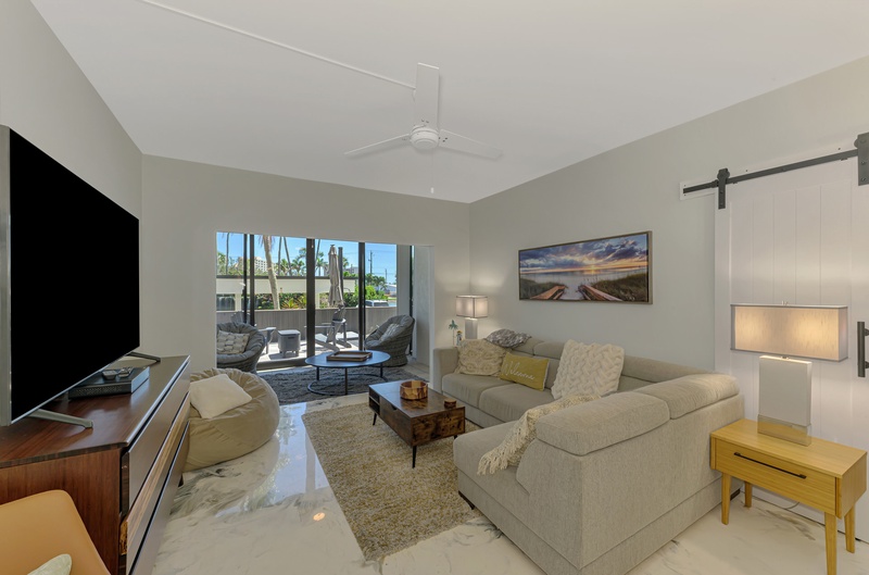 Relax in your bright living room with cozy seating, modern fireplace, and peaceful patio views.