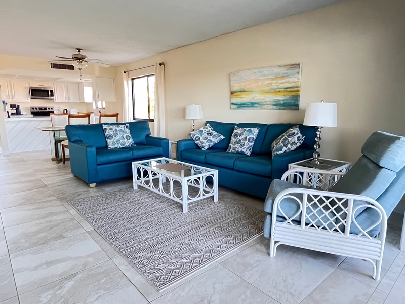 Sink into comfortable seating where ocean blues meet coastal whites, creating your perfect space to unwind after beach adventures.