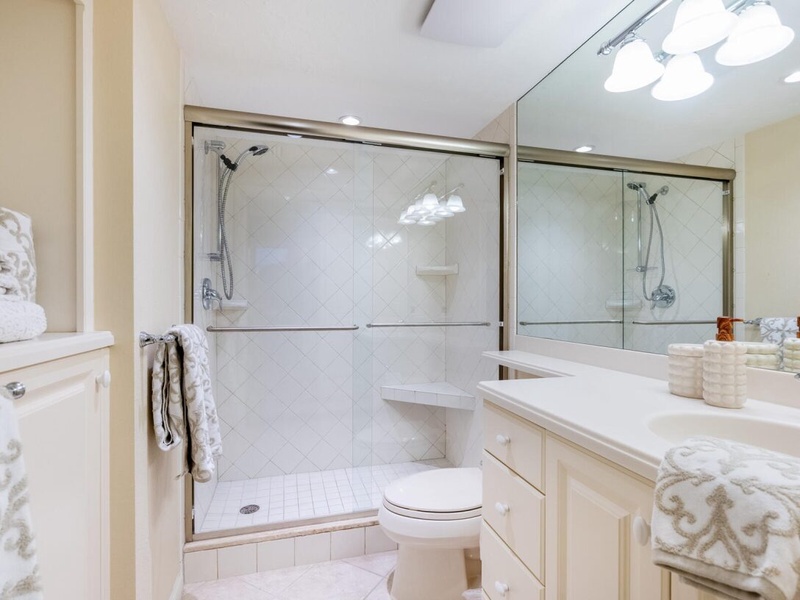 Step into your spa-like bathroom sanctuary with gleaming white subway tiles, spacious glass shower, and plush towels awaiting your arrival.