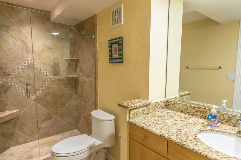 Your elegant bathroom features a spacious walk-in shower with beautiful stone tile and a granite vanity for luxurious comfort.