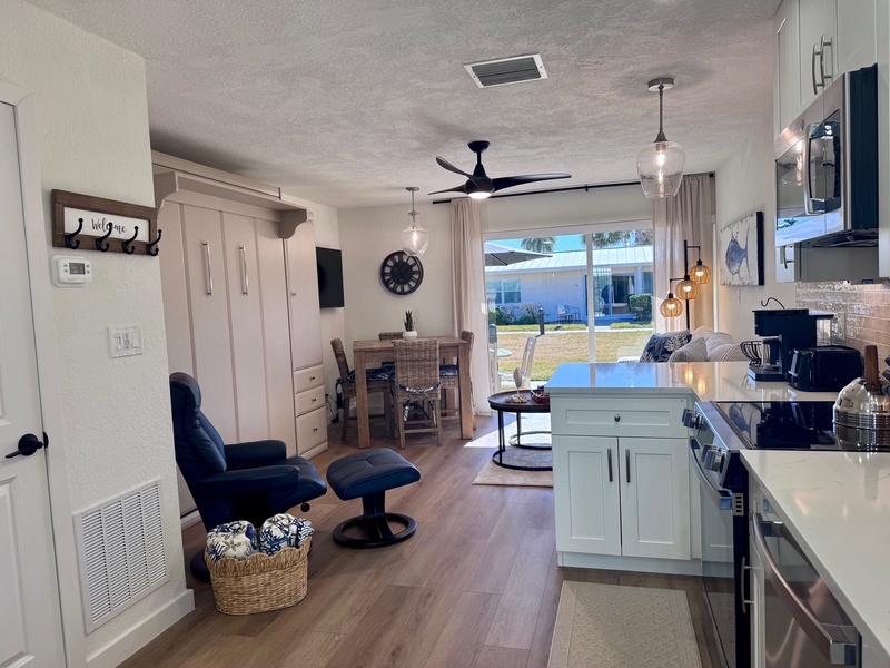 Relax in your open-plan retreat where modern kitchen flows into cozy living space with stylish seating and warm natural light.