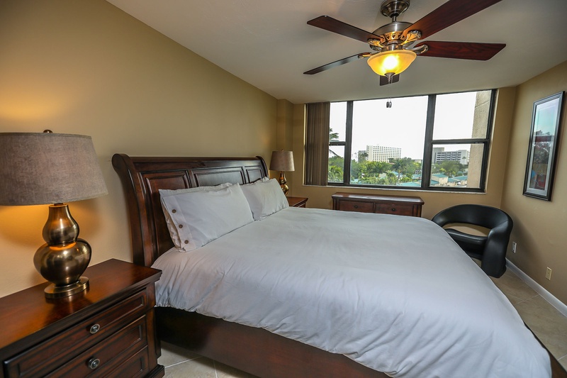 Unwind in your elegant bedroom with plush bedding and city views from large windows.