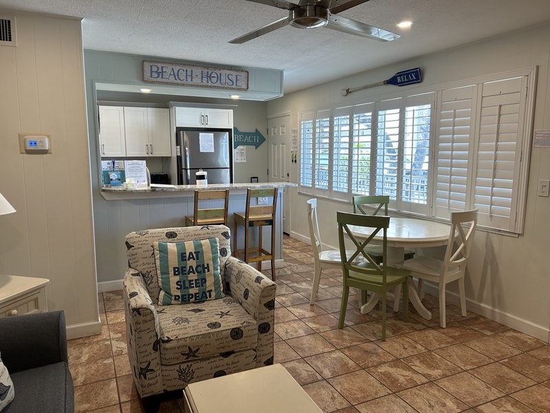 Relax in your bright, beach-themed space with coastal decor, modern kitchen, and cheerful dining area perfect for morning coffee.