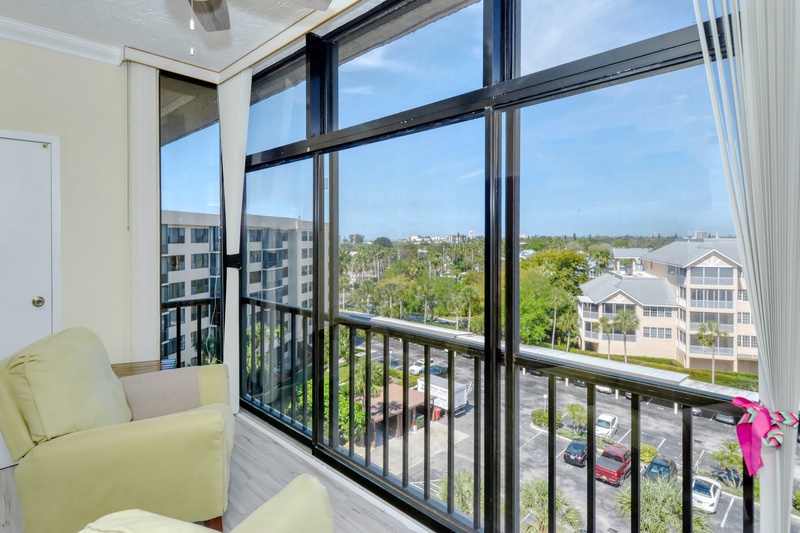 Unwind in your private retreat with panoramic windows framing lush palm trees and city views, perfect for morning coffee moments.