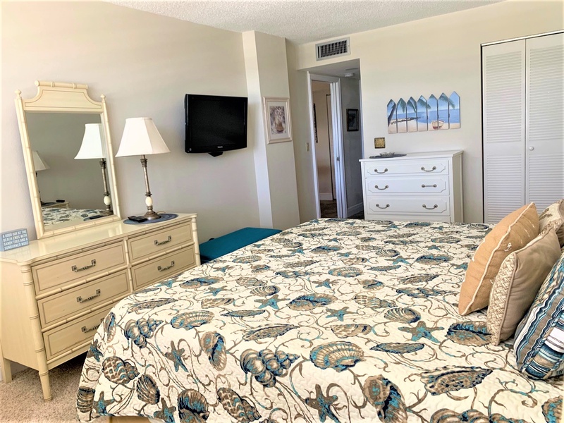 Relax in your serene coastal bedroom, where beachy blues and creams create a tranquil retreat. Your flat-screen TV awaits after beach days.