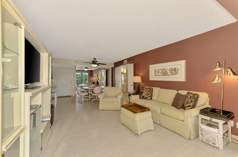 Relax in your spacious living room with comfy seating, entertainment center, and warm coastal decor that makes you feel right at home.