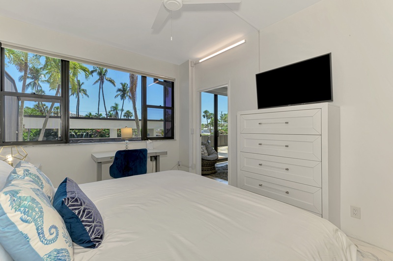 Wake up to tropical palm tree views from your comfortable bed, with modern amenities and terrace access for the perfect morning retreat.