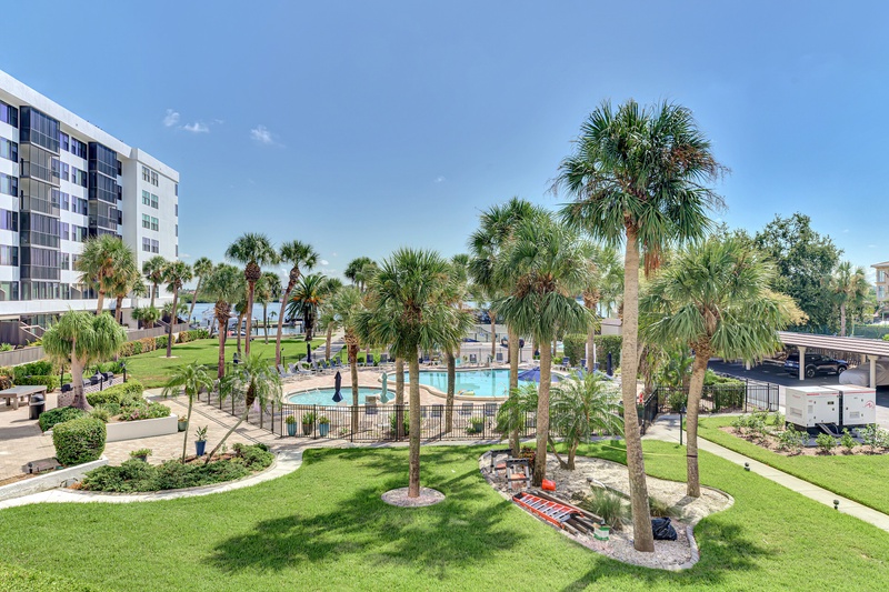 Modern property surrounded by lush tropical landscaping with palm trees and manicured grounds featuring a resort-style pool.