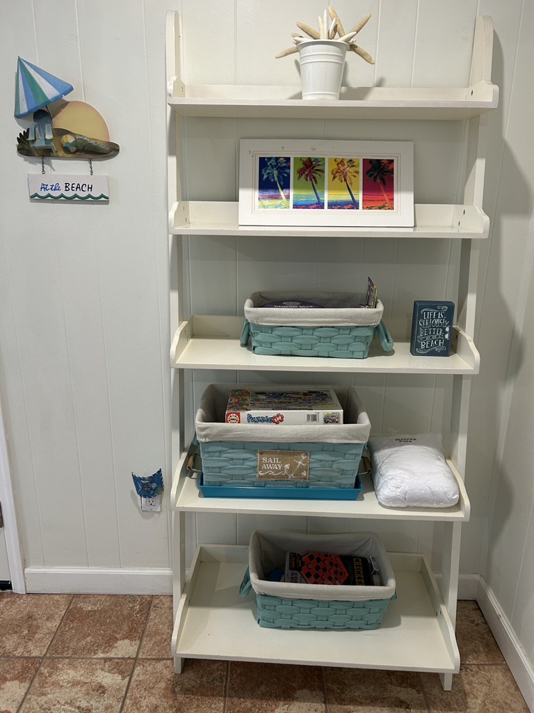 Your coastal-themed shelving unit holds beach games, books, and towels - everything you need for perfect seaside getaways right at your fingertips.
