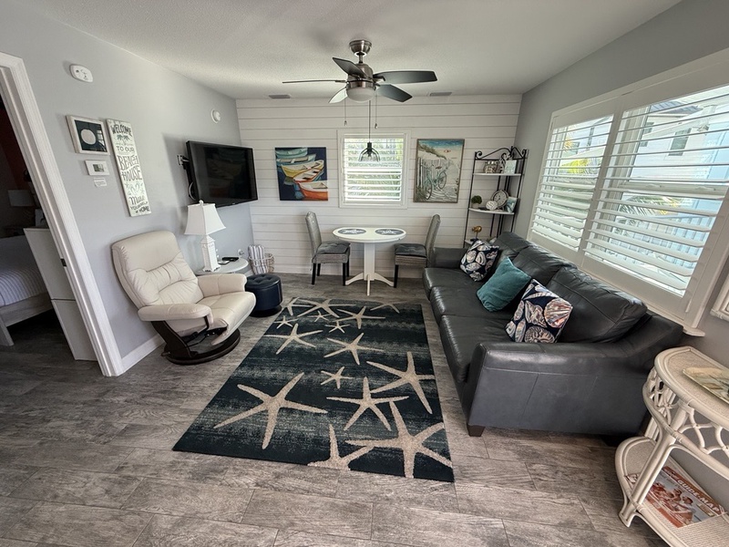 Relax in your coastal-themed living space with plush leather seating, nautical artwork, and a dining nook perfect for morning coffee.