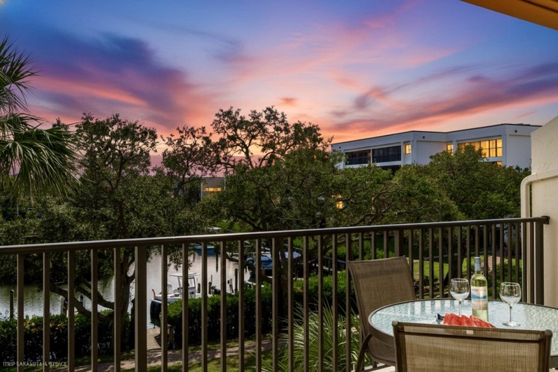 Spectacular sunset views from a private balcony with outdoor dining setup overlooking lush tropical scenery.