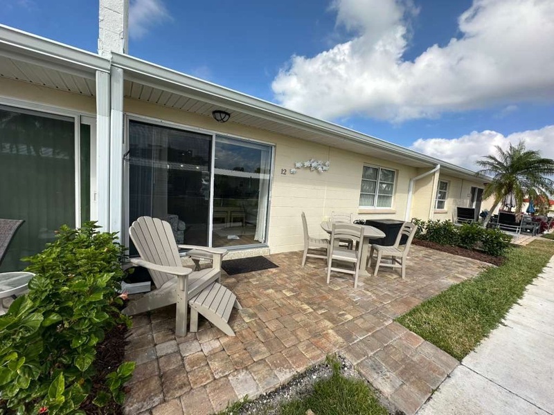 Relax on your private brick patio with comfortable outdoor seating, perfect for morning coffee or evening conversations under the Florida sky.