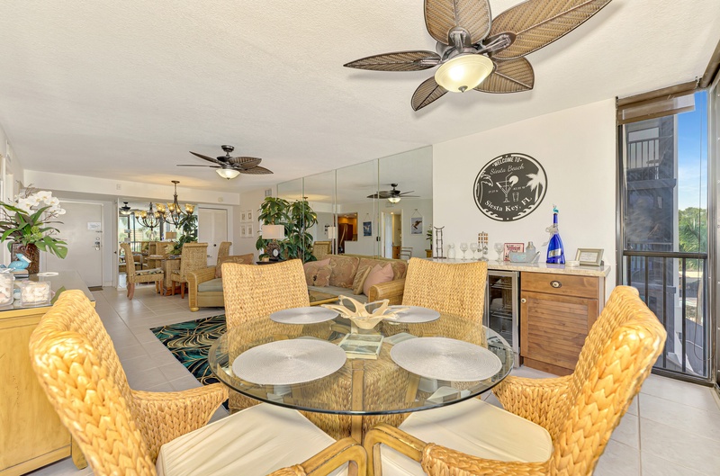 Gather around your sunny dining table with woven chairs, while tropical ceiling fans keep you comfortable in this bright, open space.