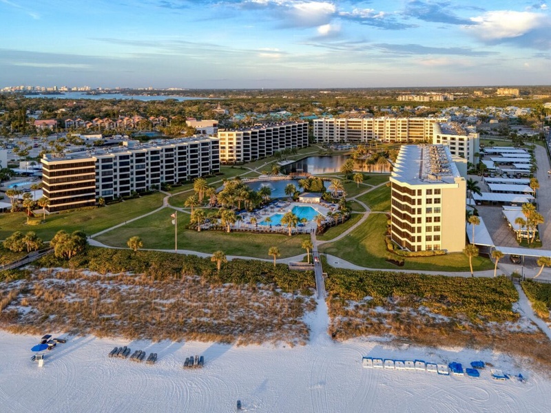 Beachfront resort complex with multiple buildings, pool facilities, and direct beach access on pristine white sand coastline.