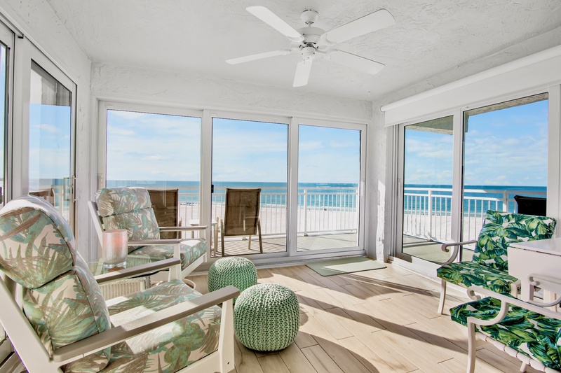 Your bright oceanfront living room opens to endless sea views through floor-to-ceiling windows, creating the perfect coastal retreat.