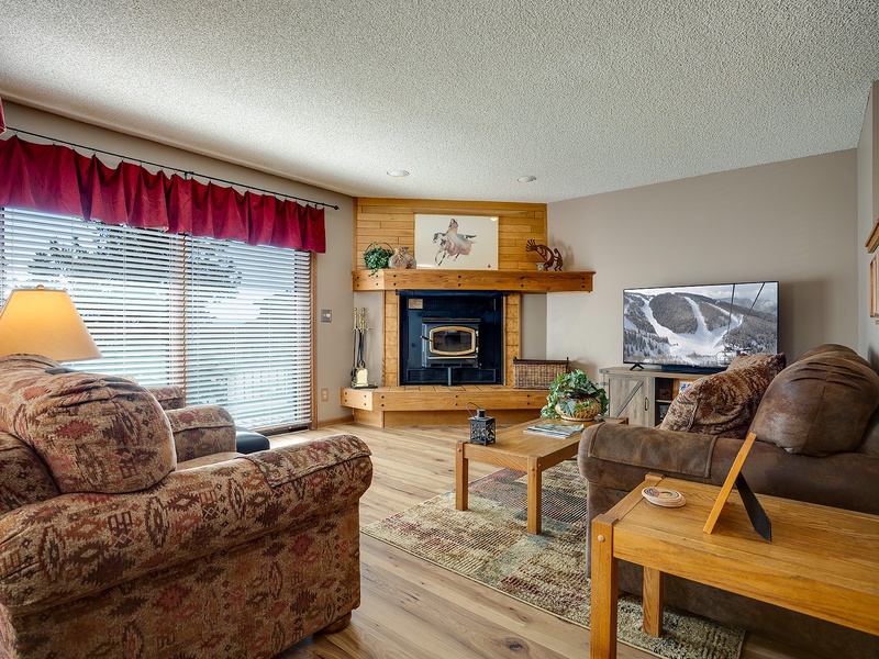 Curl up in this cozy living room where your favorite shows await on a large-screen TV, while the wood fireplace adds mountain charm to your evenings.