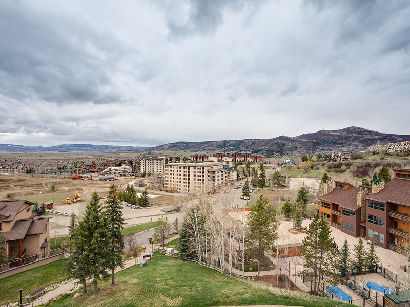 Aerial view of the property nestled in a scenic mountain valley, surrounded by natural landscape and neighboring developments.