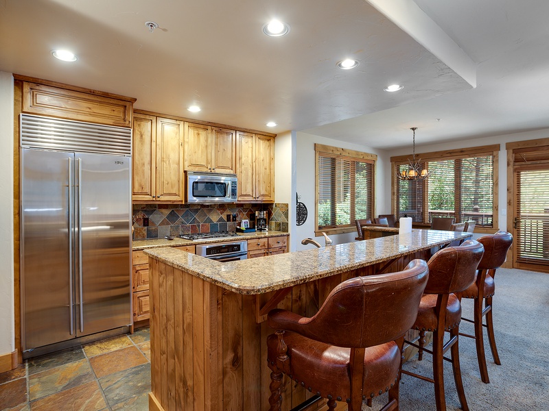 Step into your home-away-from-home kitchen, where granite countertops and warm wood cabinetry invite you to gather around the breakfast bar with family and friends.